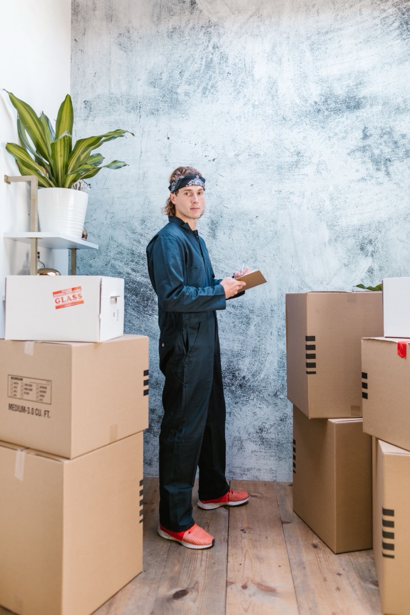 Mover taking inventory of boxes on a clipboard